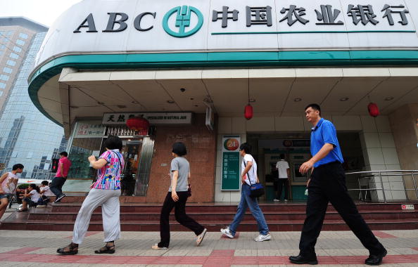 Pedestrians walk past a branch of the Ag