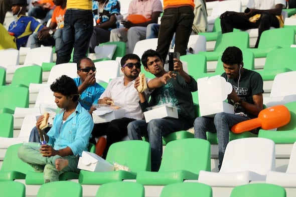Migrant workers take a selfie as they watch the final soccer match between Taleb Group and Gulf Contracting at Qatar Workers Cup, in Doha