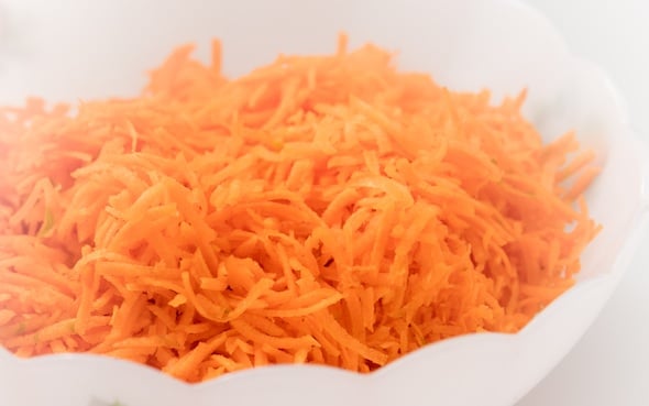 Grated carrots in kitchen bowl.